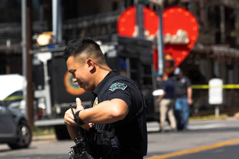 A police officer radios for backup near the scene of a mass shooting at a bar in Austin, Texas, that left two dead and 14 injured on March 1, 2025. (Photo Credit: Reuters)