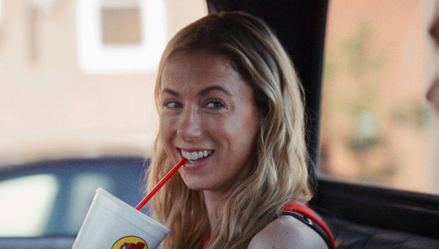 Iliza Shelsinger smiles and holds a Buc-ee's cup in a still image from the film "Chasing Summer."