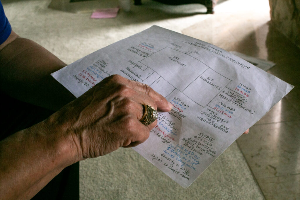 Encarnacion Serna, a retired chemical engineer, explains a diagram and calculations he made of one of the city's desalination projects. Credit: Dylan Baddour/Inside Climate News