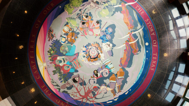 Aerial view of a colorful terrazzo floor depicting different characters sitting around a campfire.