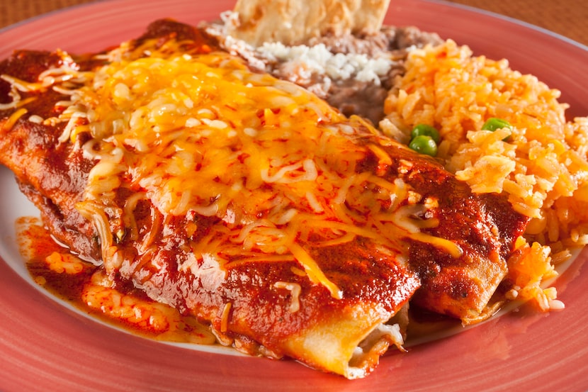 Yellow cheddar cheese is almost always on top of Tex-Mex enchiladas.