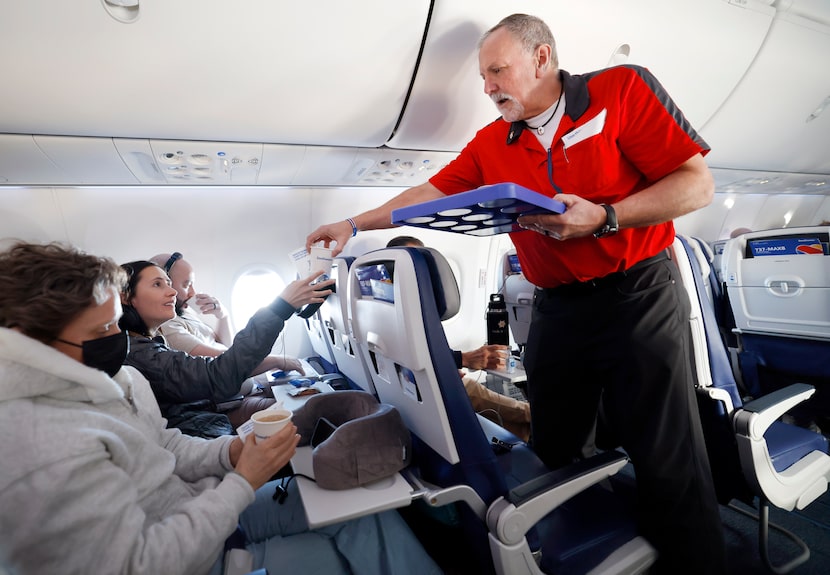 Southwest Airlines flight attendant BR Ricks serves drinks to passenger Becca Gourgues of...
