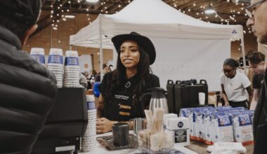 A woman in black cowboy hat serves coffee at the Dallas Coffee Festival.