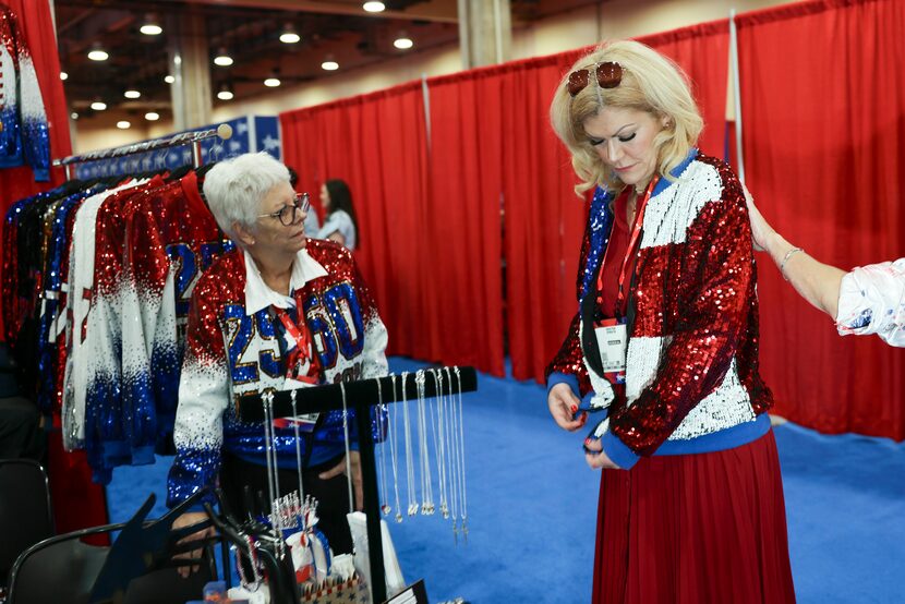 Dina Vitacca (left) watches as Kristen Gunaca tries a sequin jacket in the exhibit hall...