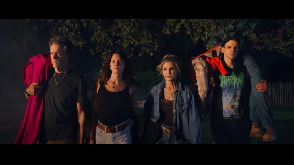 Kevin Bacon, Kyra Sedgwick and two of their children in a nighttime still image from the film 