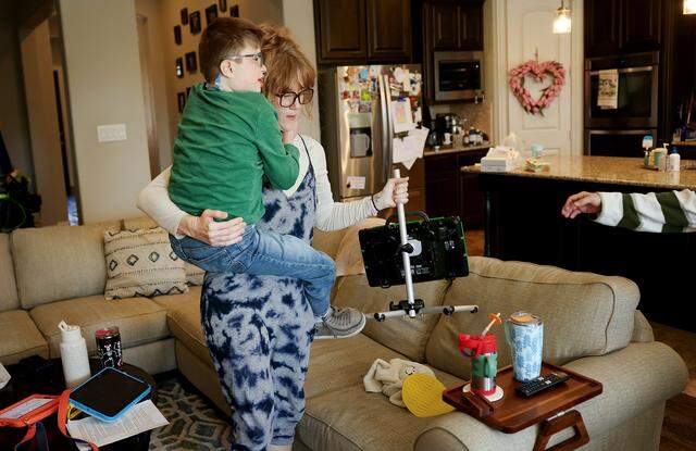 Respite provider Beth Ward cares Luke Lunday, 12, and his augmentative and alternative communication device while helping to care for him at his Trophy Club home on Friday, March 13, 2026.