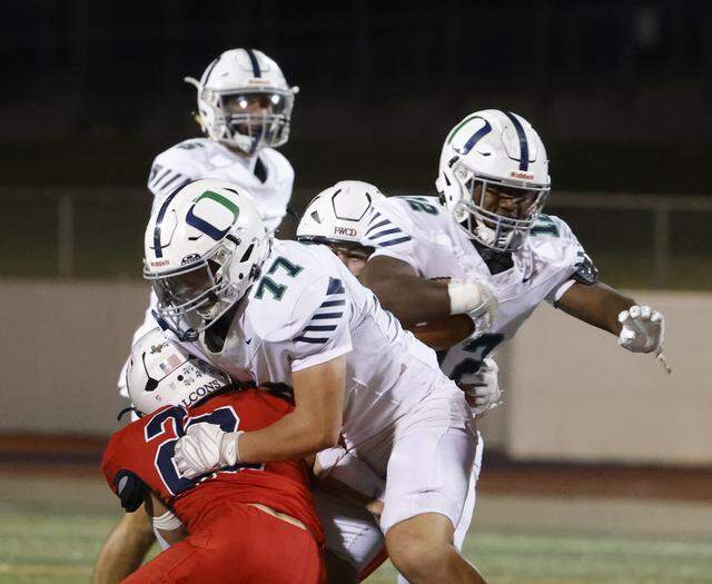 Oakridge end Joshua Dees (12) follows his lead blocker lineman Wyatt Gray (77) through the hole during the first half of the SPC 2025 3A Football Championship football game between The Oakridge School and Fort Worth Country Day at Mavericks Stadium in Arlington, Texas, Saturday Nov. 08, 2025.