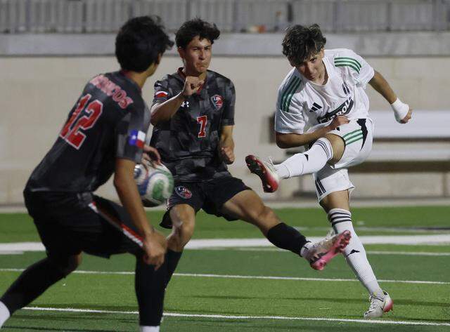 Southlake Carroll’s Jad Shehadeh kicks the ball between Mansfield Legacy midfielder Joseph Murillo and defender Alan Mendiola during the first half of a UIL bi-district round soccer playoff game at Crowley ISD Multi-Purpose Stadium in Fort Worth, Texas, on Friday, March 20, 2026.