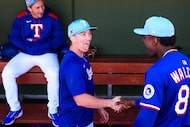 Texas Rangers infielder Cam Cauley shakes hands with infielder Sebastian Walcott before  a...