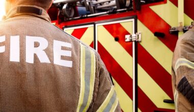 Firefighters stand beside a fire truck, illustrating the Austin Fire Department case involving former chaplain Andrew Fox.