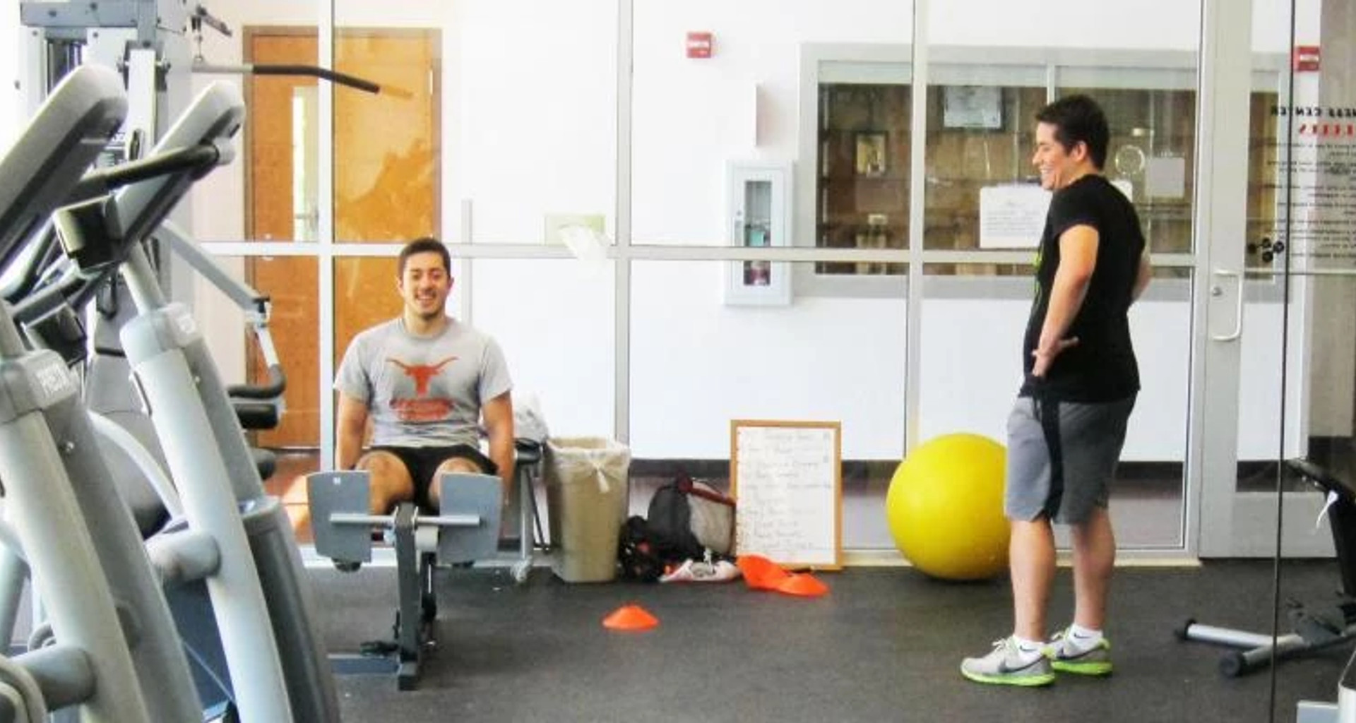 Two men exercising on weightroom machines