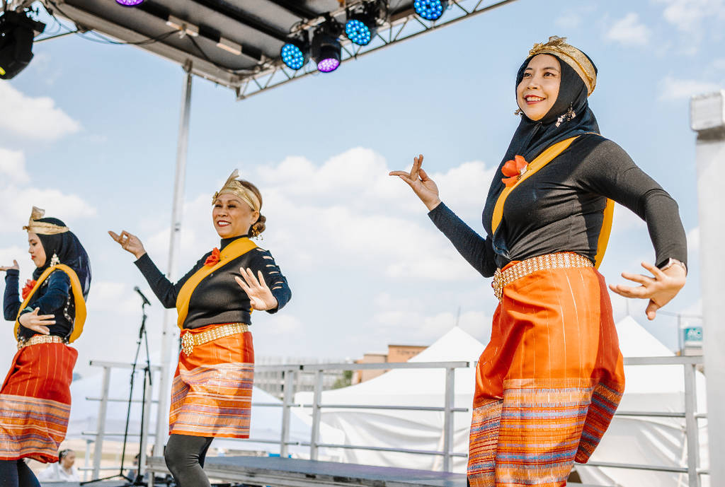 Image shows three dancers performing onstage at Panda Fest. 