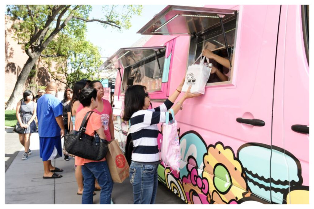 Image shows the Hello Kitty Cafe Food truck surrounded by customers.