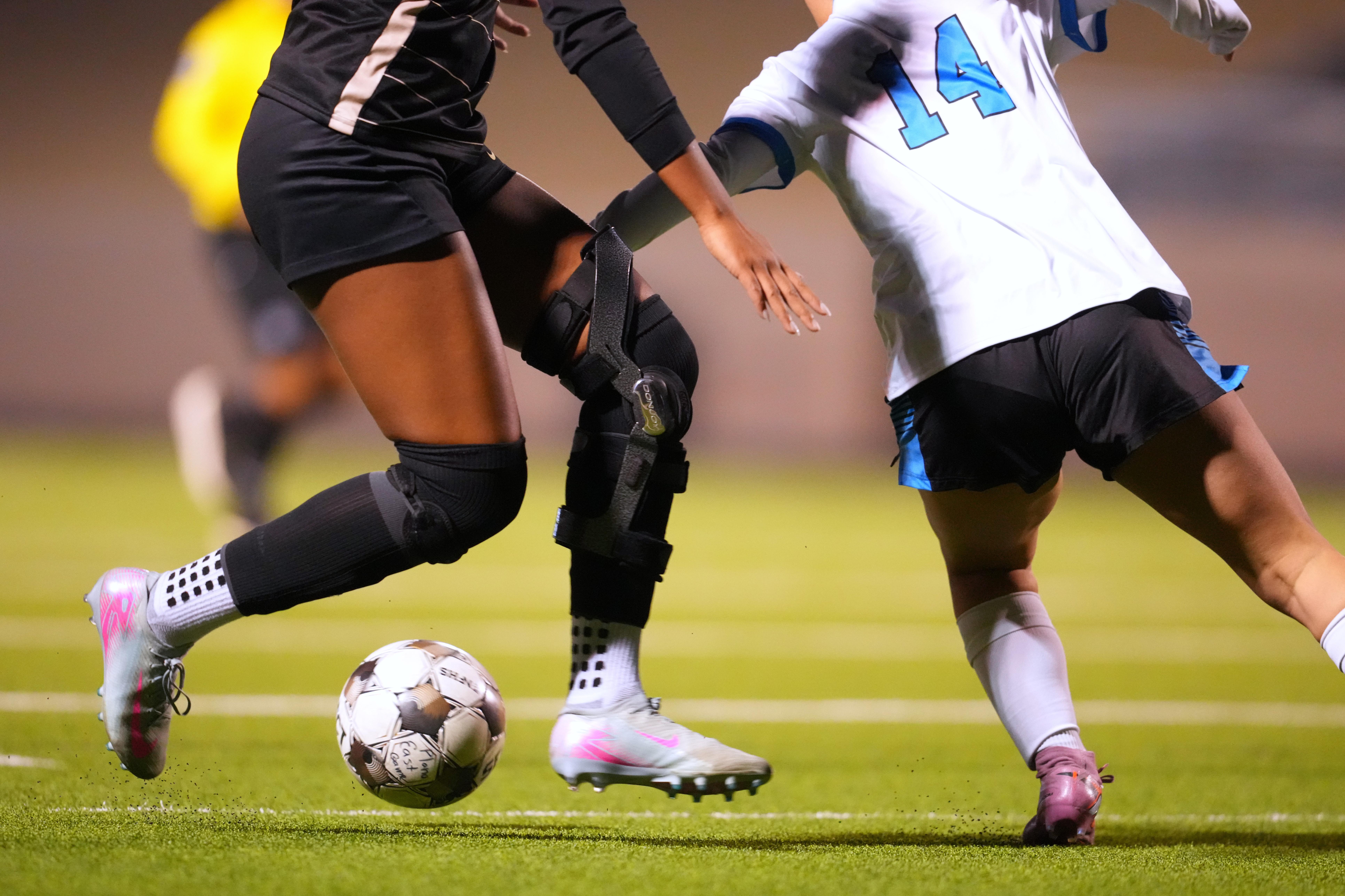 Plano East varsity soccer player Aliya Jacob's knee brace is visible during a game.