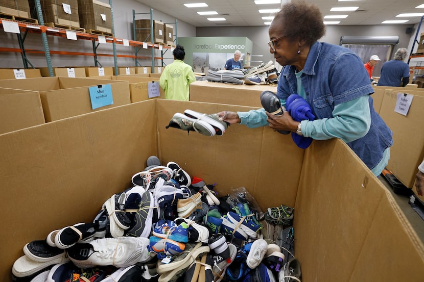 Carolyn Griffith of Dallas, a volunteer for Buckner Shoes for Orphan Souls program, sorts...