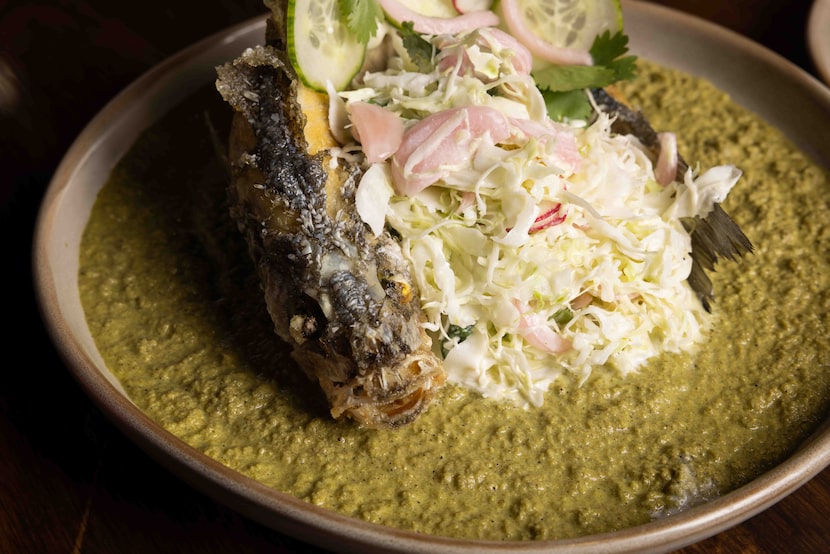 The fried fish tacos — made with a whole branzino, tomatillo salsa, cabbage slaw and served...