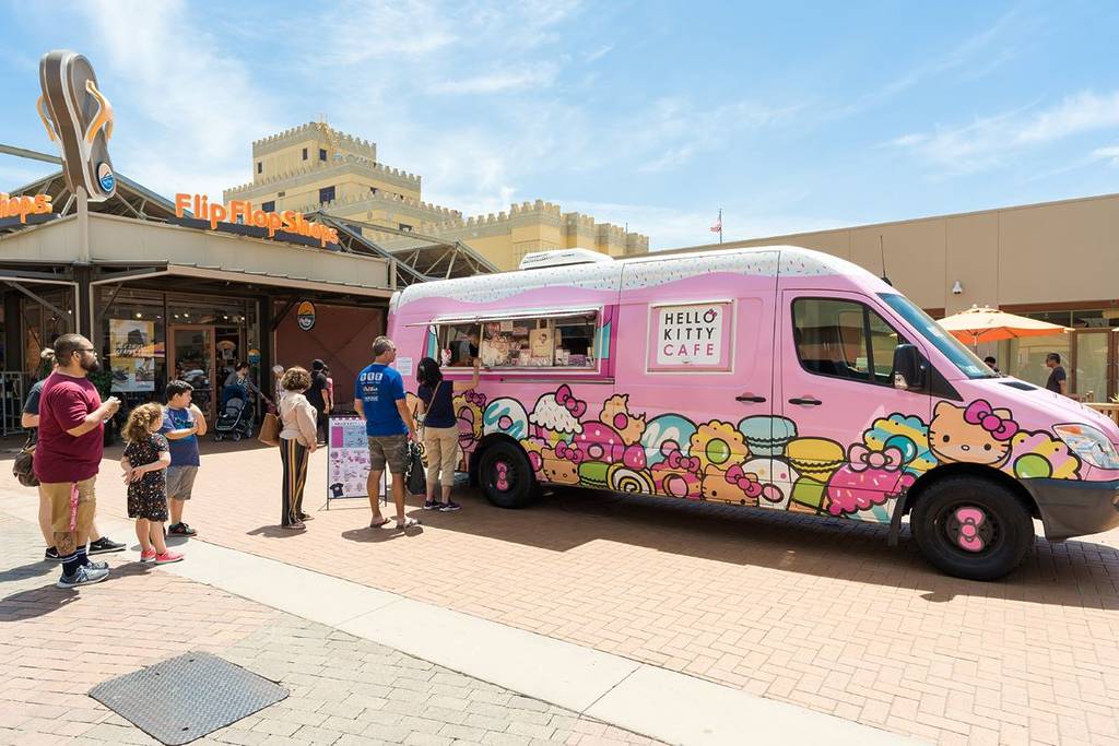 Image shows the Hello Kitty Cafe Truck with visitors standing in line. 