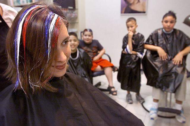 June 13, 2003: Noreen Crockett, left, of Fort Worth models red, white and blue colored styling glue at Trade Secret hair salon in Ridgmar Mall. The anxious youngsters who are next in line for the coloring are Francisco Flores, 10, Danny Waits, 8, Jim Rodela, 11, and Gina Boughton, 12. The shop was giving the complementary stylings to interested passerby in observance of Flag Day.