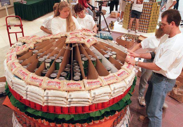 Nov. 5, 2000: Gwynne Morrison, Carol Cameron and Jason Guree, members of the Huitt-Zollar Engineering Firm, put the bun on their Canstruction 2000 competition entry, a 'Can-Caid's' hamburger, at Ridgmar Mall in Fort Worth.