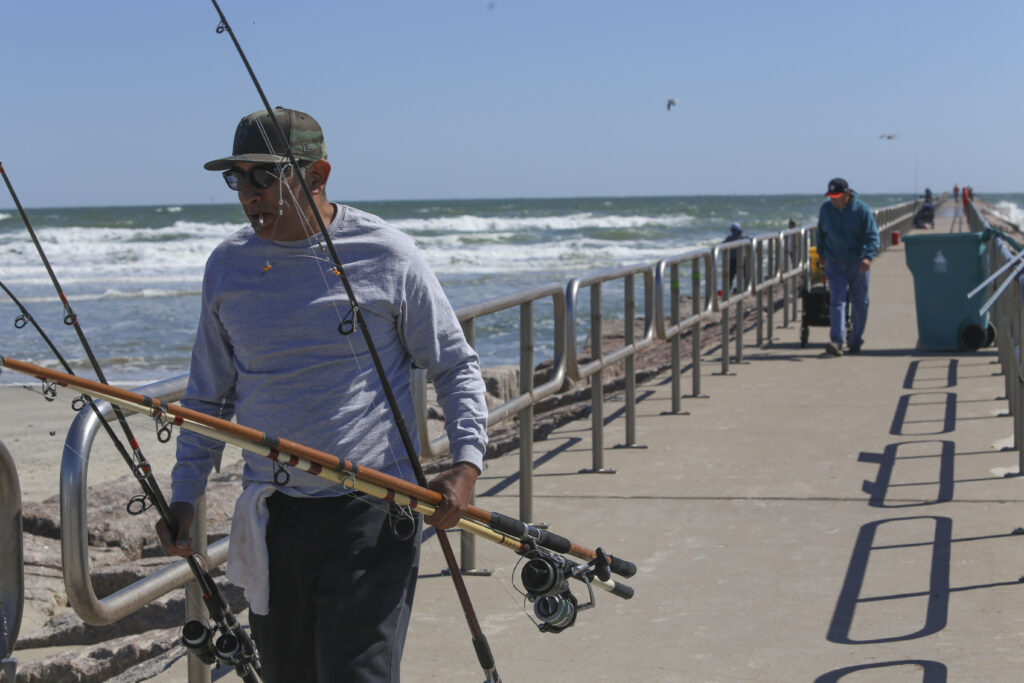 Fisherman at a jetty in the Gulf of Mexico at North Padre Island, across the bay from Corpus Christi, on a Wednesday afternoon in October.