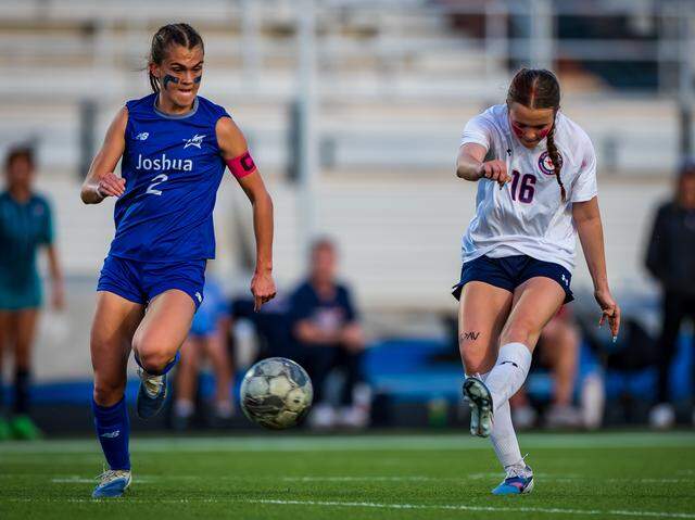 Grapevine’s Ella Wilson (16) scores the game-winning goal in the 77th minute as Joshua’s Kynli Miller (2) defends in a Class 5A Division 2 area-round match on Tuesday, March 24, 2026 at Brewer High School in Fort Worth, Texas.