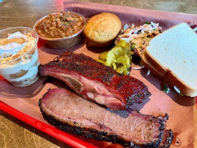 Brisket, pork ribs, slaw, beans and banana pudding on a typical platter from Terry Black’s Barbecue.