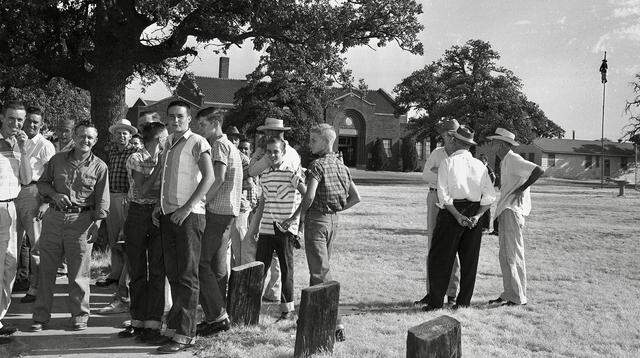 Mansfield High School boys and adults guard the entrance to the school on Aug. 30, 1956, to prevent Black students from registering as an effigy hangs from the flagpole.