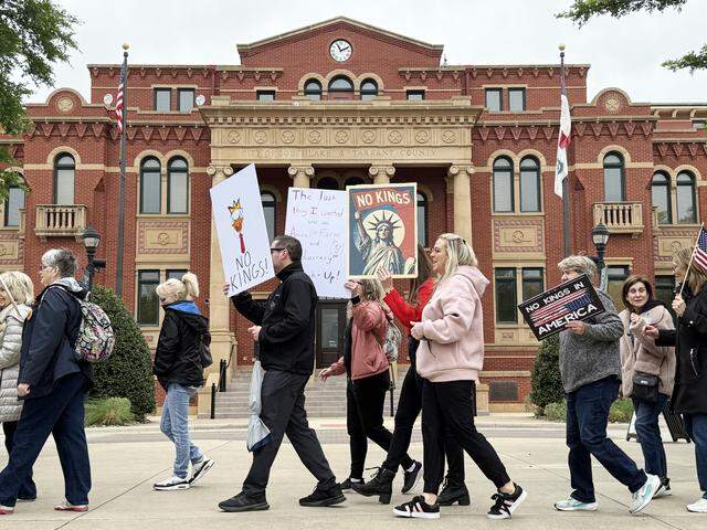 Protestors march around the park in front of Southlake City Hall chanting and holding “No Kings” signs during a rally on Saturday, March 28, 2026.