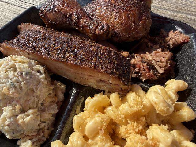 A North Texas Smoke BBQ plate with pork ribs, chicken and chopped brisket, along with mac-and-cheese and loaded-baked-potato salad, seen Nov. 22, 2025.