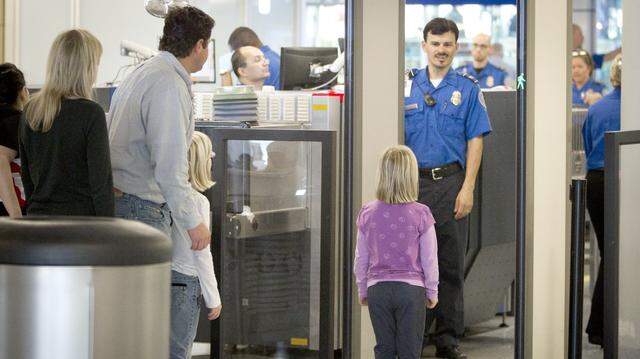 Tim and Jenny Stobaugh of Dallas prepare to go through security at DFW Airport with their children Delia, 6, (preparing to step through the metal detector) and Emery, 8, on Wednesday, November 24, 2010 on their way to Calgary for the holidays.  (Star-Telegram/Joyce Marshall)