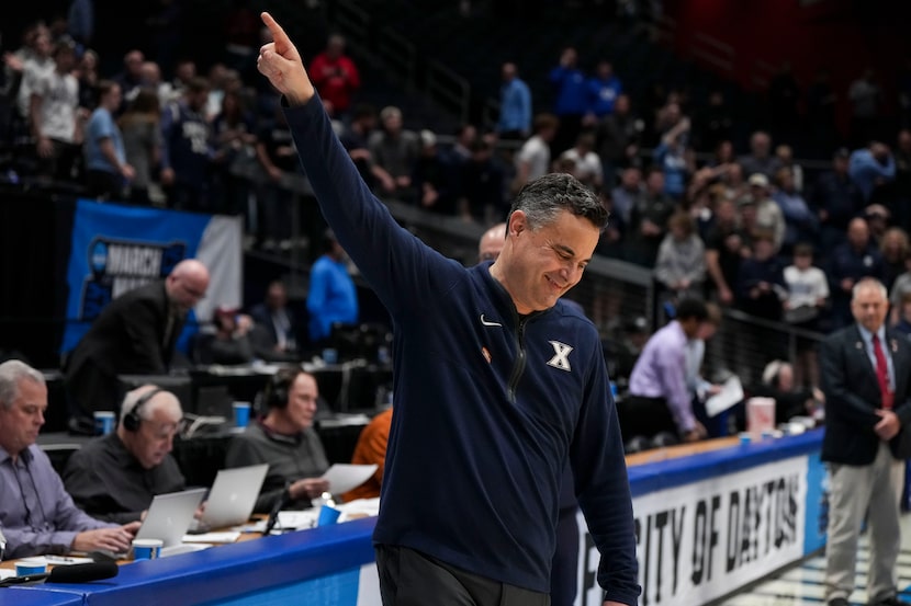 Xavier head coach Sean Miller gestures to fans following their victory over Texas during a...