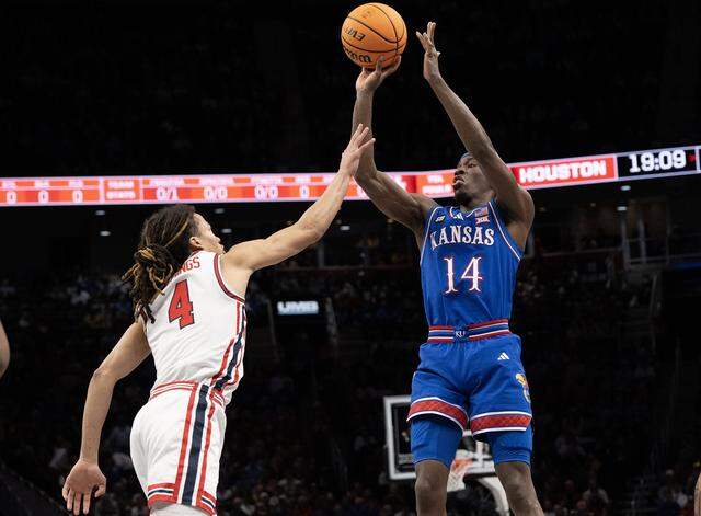 Kansas Jayhawks guard Melvin Council Jr. (14) gets a shot off as Houston Cougars guard Kingston Flemings (4) defends in the first half at the Big 12 Men's Basketball Tournament at T-Mobile Center on Friday, March 13, 2026, in Kansas City.