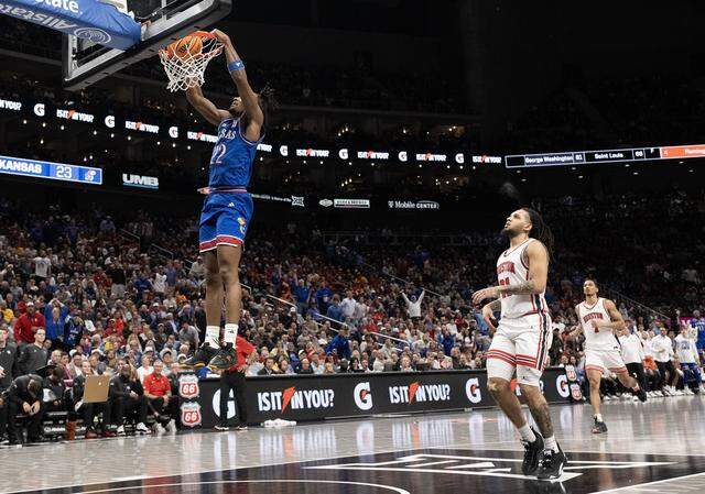 Kansas Jayhawks guard Darryn Peterson (22) slams a dunk in the first half as Houston Cougars guard Emanuel Sharp (21) looks on at the Big 12 Men's Basketball Tournament at T-Mobile Center on Friday, March 13, 2026, in Kansas City.