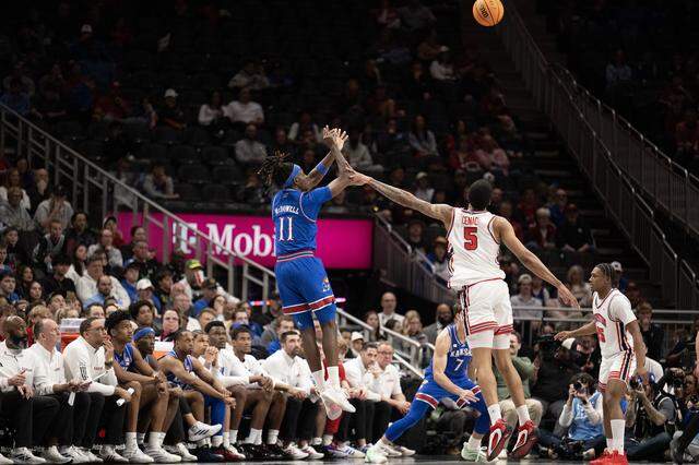 Kansas Jayhawks guard Jamari McDowell (11) shoots a three-point shot as Houston Cougars center Chris Cenac Jr. (5) defends in the second half at the Big 12 Men's Basketball Tournament at T-Mobile Center on Friday, March 13, 2026, in Kansas City. Houston defeated Kansas, 69-47.