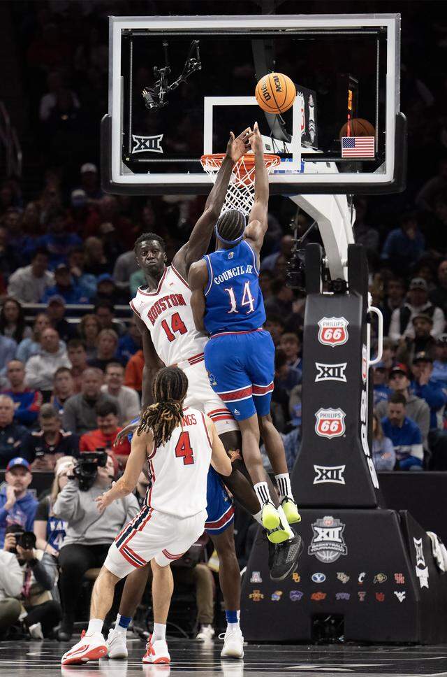 Kansas Jayhawks guard Melvin Council Jr. (14) gets a shot off as Houston Cougars forward Kalifa Sakho (14) defends in the second half at the Big 12 Men's Basketball Tournament at T-Mobile Center on Friday, March 13, 2026, in Kansas City. Houston defeated Kansas, 69-47.