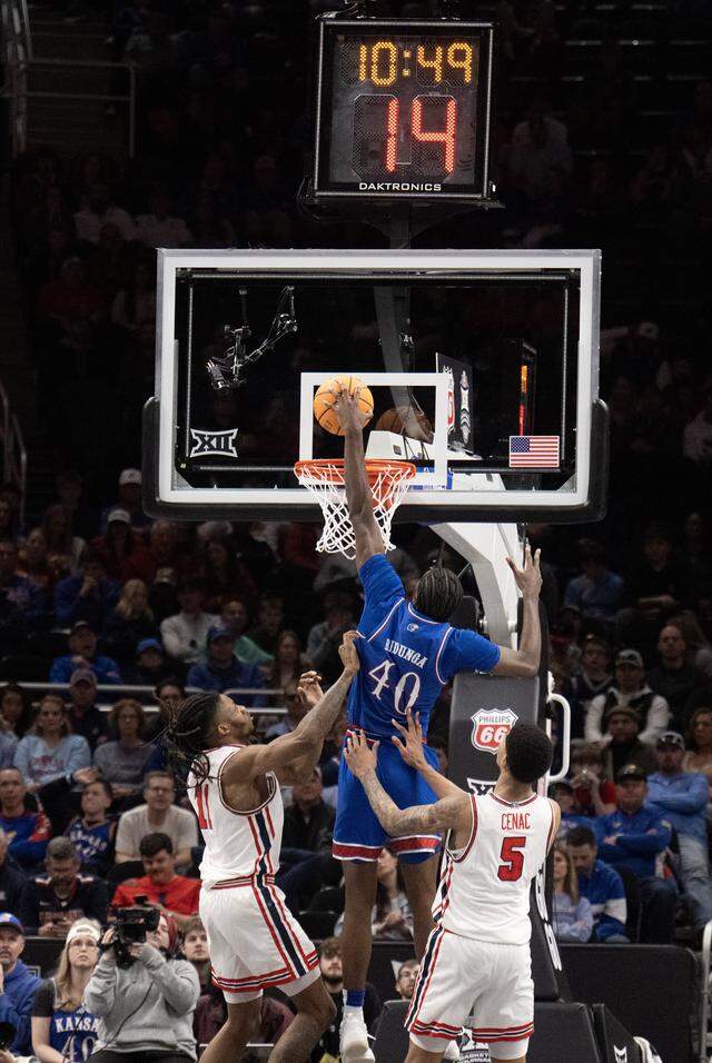 Kansas Jayhawks forward Flory Bidunga (40) goes to the rim as Houston Cougars guard Emanuel Sharp (21) and Houston Cougars center Chris Cenac Jr. (5) defend in the second half at the Big 12 Men's Basketball Tournament at T-Mobile Center on Friday, March 13, 2026, in Kansas City. Houston defeated Kansas, 69-47.