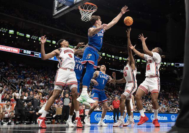 Kansas Jayhawks guard Kohl Rosario (7) blocks a shot as Houston Cougars forward Joseph Tugler (11) and others try to rebound the ball in the second half at the Big 12 Men's Basketball Tournament at T-Mobile Center on Friday, March 13, 2026, in Kansas City. Houston defeated Kansas, 69-47.
