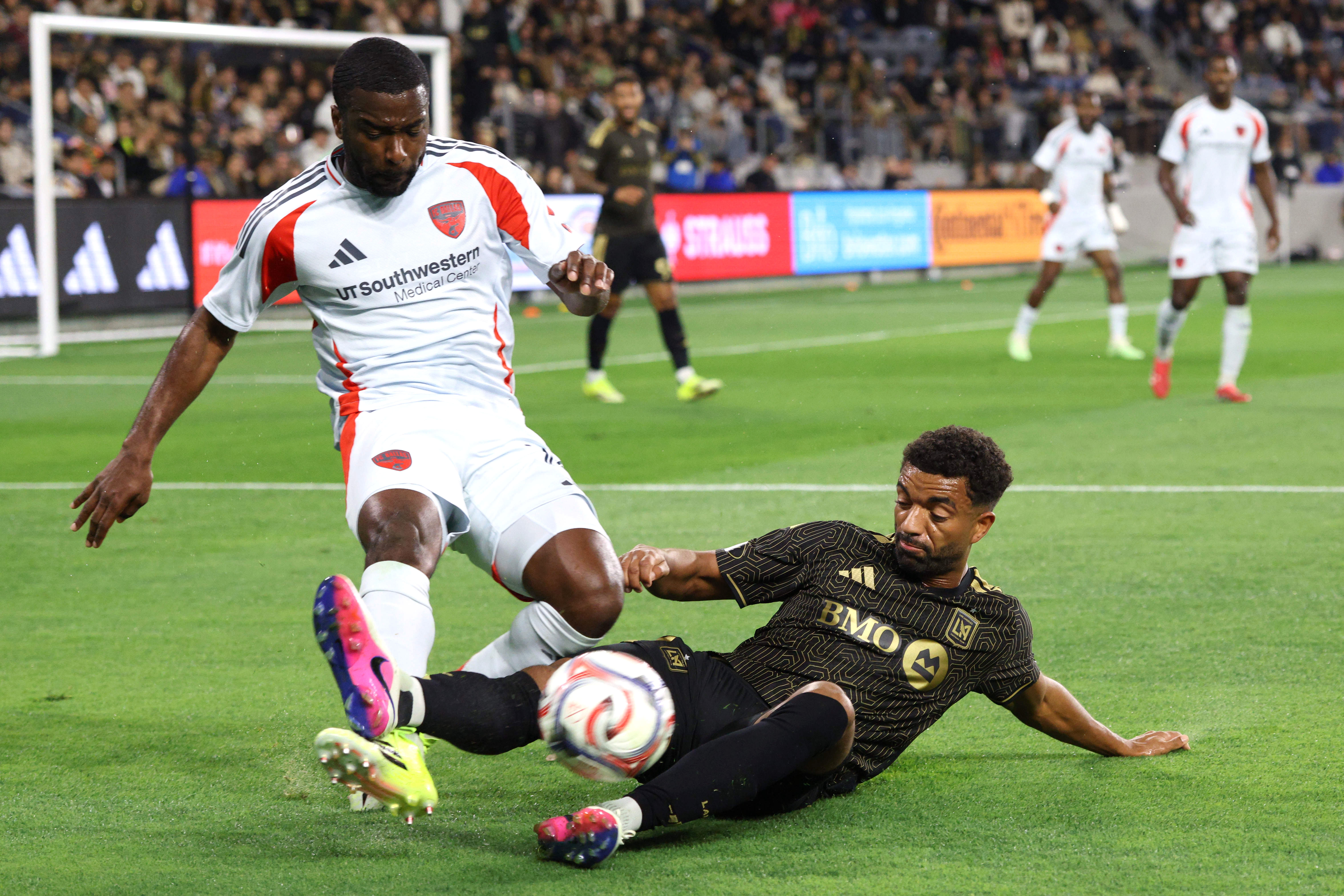 LAFC midfielder Timothy Tillman, bottom, slide tackles FC Dallas defender...