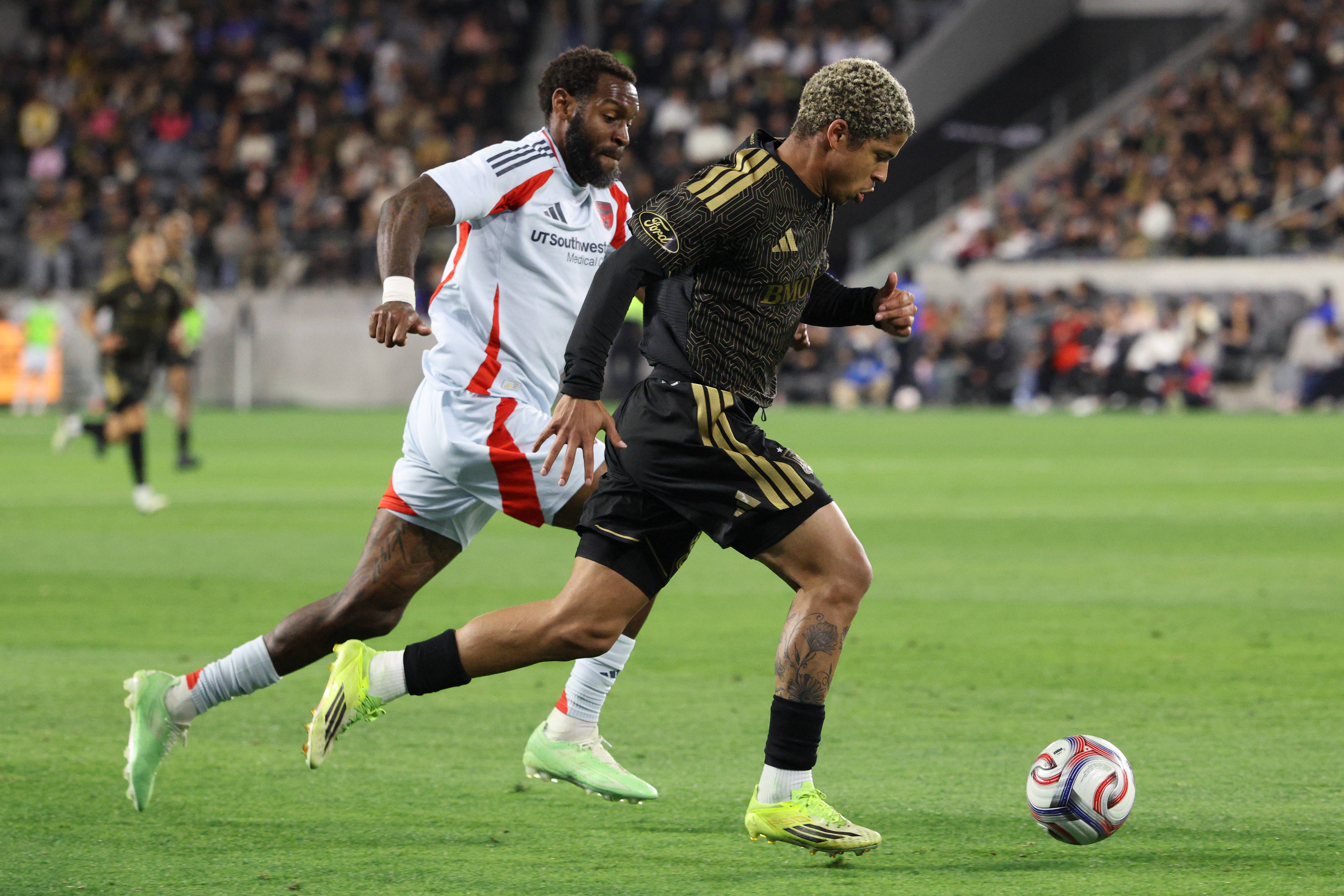LAFC forward David MartÃnez, front, moves the ball chased by...