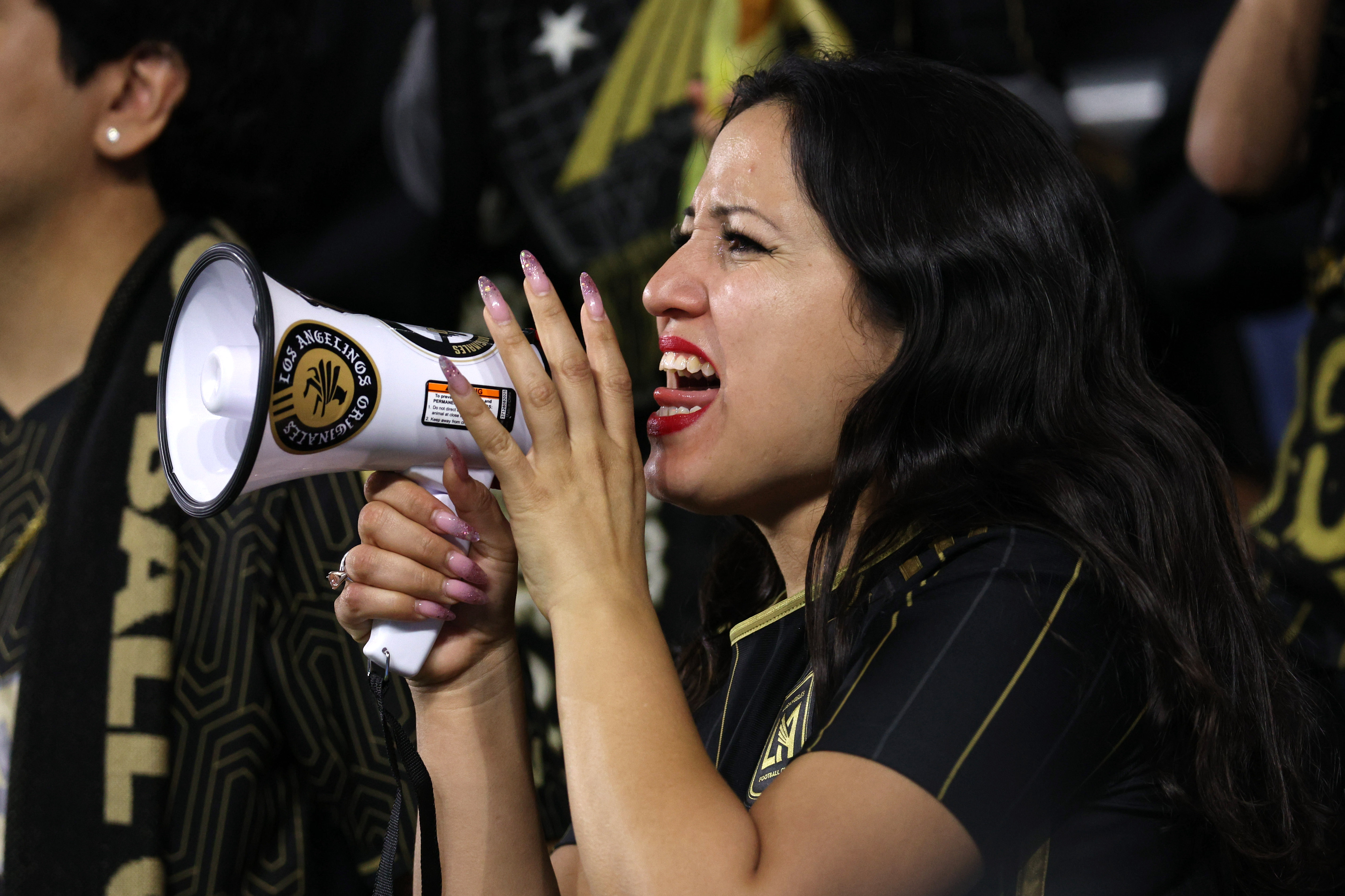 A LAFC fan cheers with a megaphone during the second...
