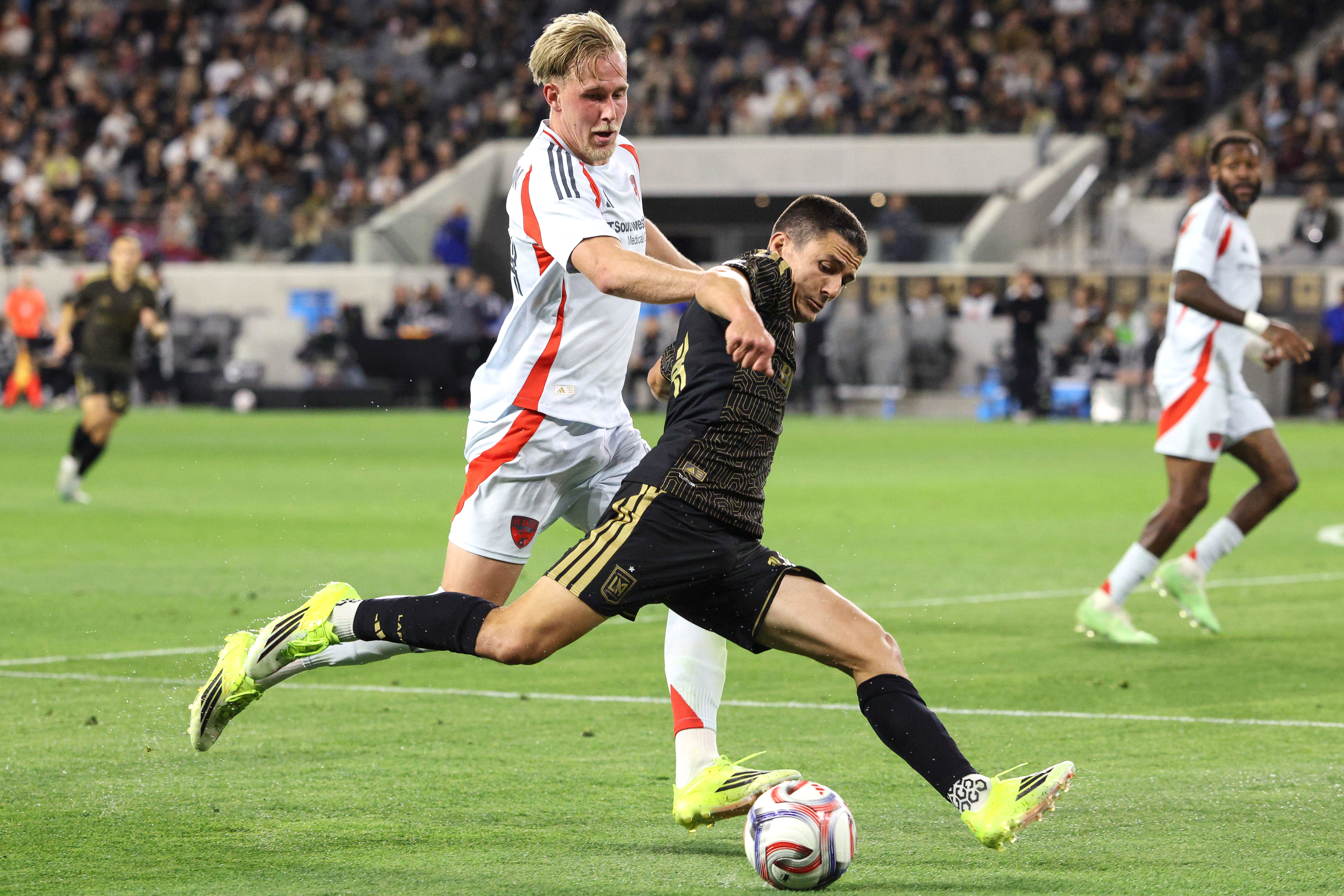 LAFC defender Sergi Palencia, front, winds up to kick the...