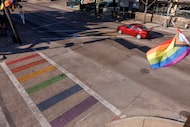 A car drives past rainbow crosswalks at the intersection of Cedar Springs Road and...