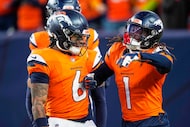 Denver Broncos' P.J. Locke and Tremon Smith celebrate a fmble recovery during the second...