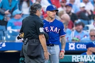 Texas Rangers manager Skip Schumaker, right, listens to umpire James Hoye, left, during the...