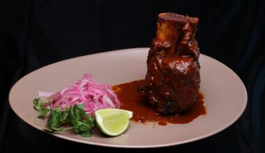 Chamorro en adobo at Manny's Mexican Kitchen, a dish of pork shank in a brick-red adobo sauce