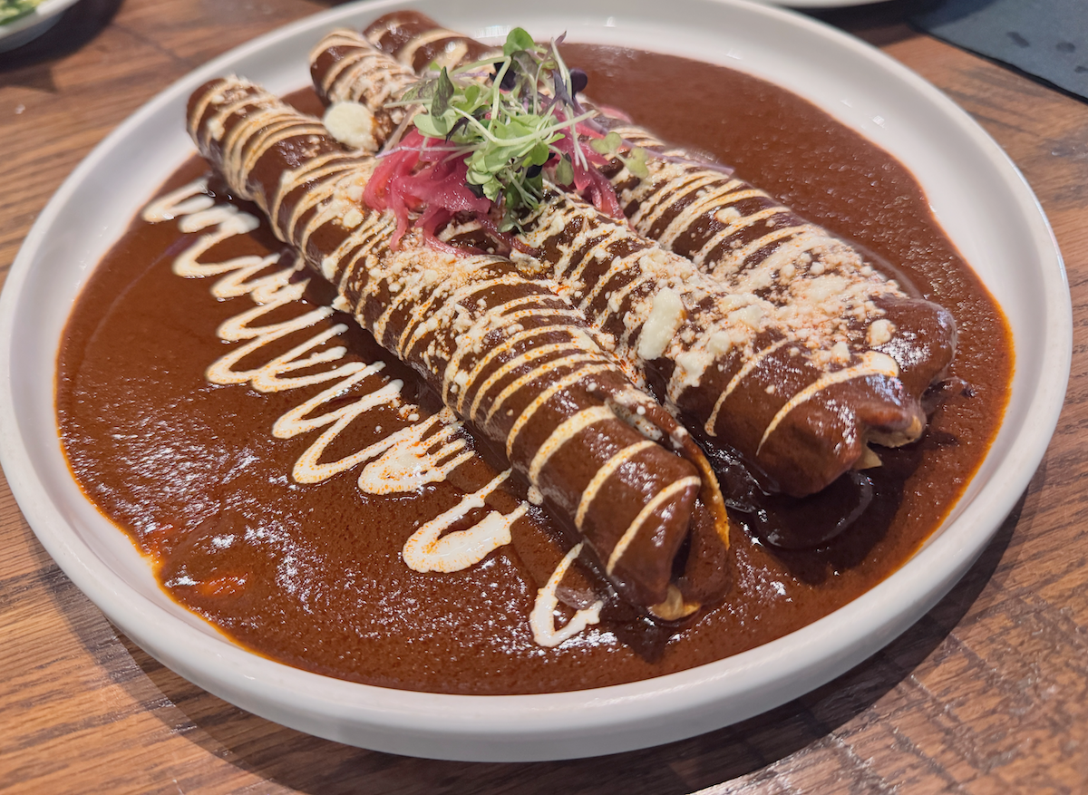 Close up of Milagro tacos cantina chicken taquitos in a mole sauce