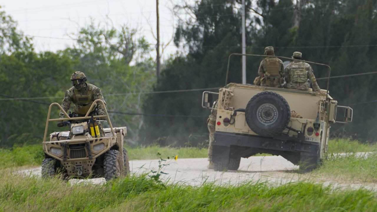 A military service member rides an all terrain vehicle along a road near the Rio Grande after crossing the Texas-Mexico border, Thursday, May 11, 2023, in Brownsville, Texas. (AP Photo/Julio Cortez)