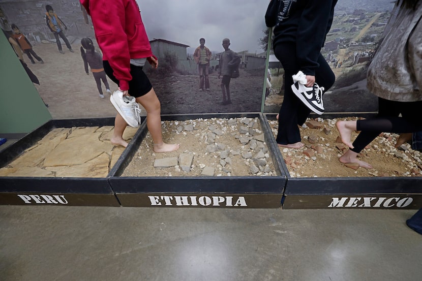 Students from Ruth Cherry Elementary School in Royse City, Texas, step onto the soil without...