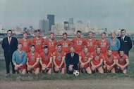 The Dallas Tornado 1968 road team poses with the downtown Dallas skyline as a backdrop....