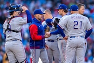 Texas Rangers manager Skip Schumaker, second from left, takes the ball from starting pitcher...